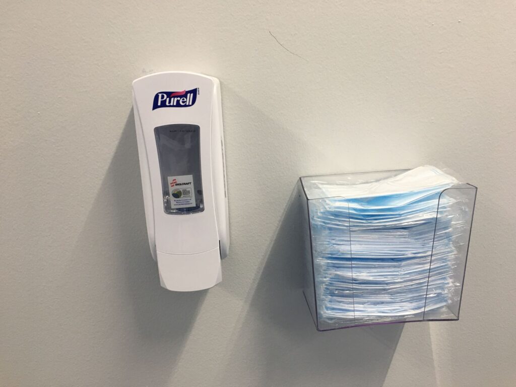 Blue face mask next to hand sanitizer